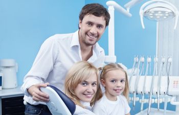 A little girl with her parents during dental appointment.