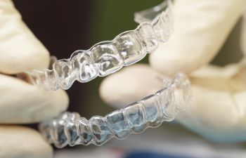 Dentist holding a set of invisible aligners.