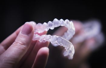 A hand holding a set of clear orthodontic aligners.