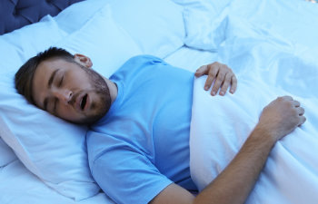 man in blue pajamas sleeping and snoring